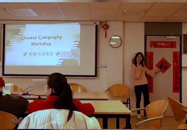 Een docent introduceert de workshop Chinese kalligrafie voor een scherm